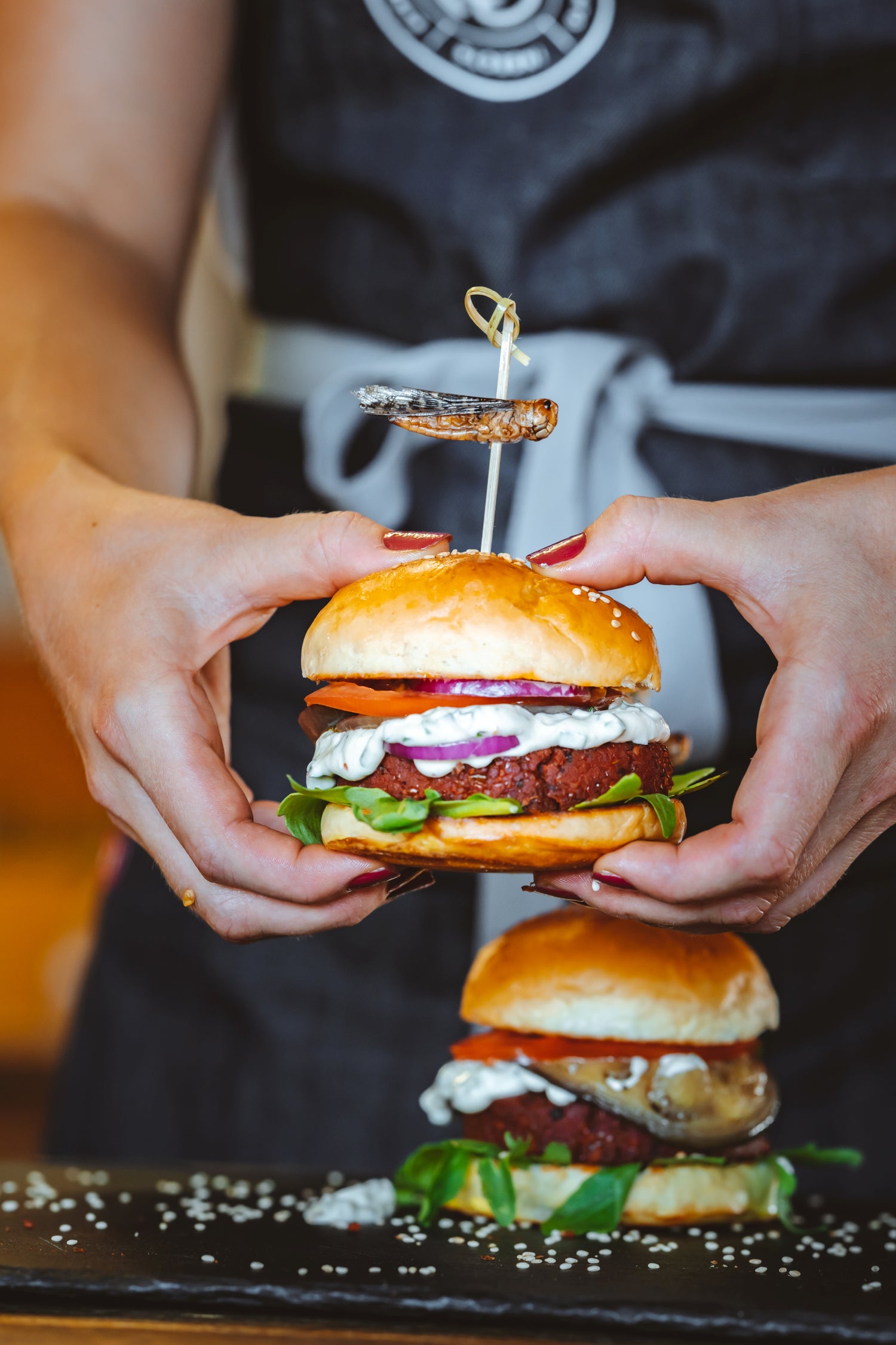 Essento Insect Burger in der Hand mit Heuschrecke